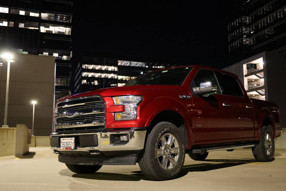 Red Ford F-150 Lariat parked on a rooftop deck at night