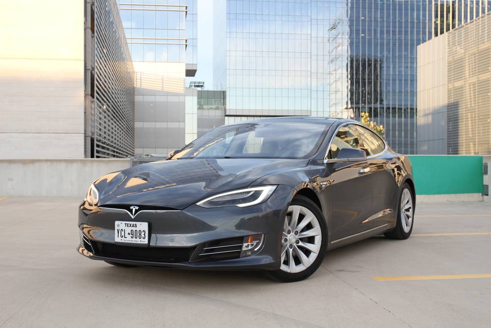 Dark grey Tesla Model S parked on a rooftop deck